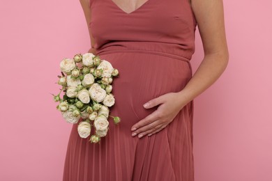 Photo of Pregnant woman in dress with bouquet of roses on pink background, closeup