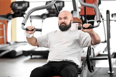 Photo of Overweight man training in gym