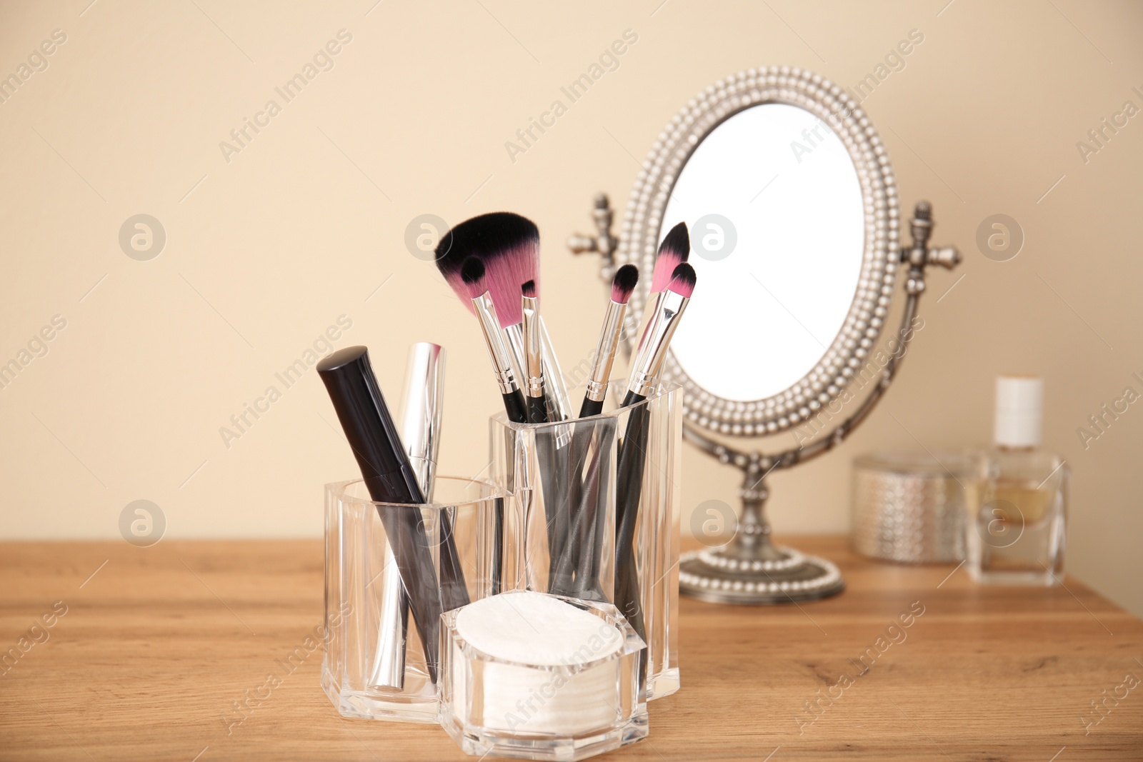 Photo of Makeup cosmetic products and tools in organizer on dressing table