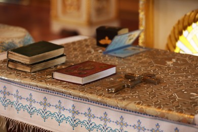 Photo of Ecclesiastical books and cross on communion table in church. Baptism ceremony