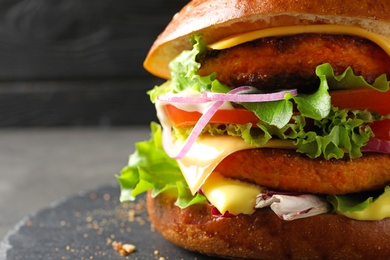 Photo of Double vegetarian burger on slate plate, closeup