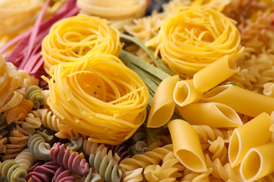 Photo of Different types of pasta as background, closeup