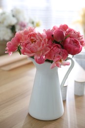 Beautiful bouquet of fragrant peonies in vase on table indoors