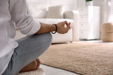 Photo of Man meditating at home, closeup. Space for text