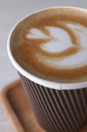 Coffee to go. Paper cup with tasty drink on white table, closeup