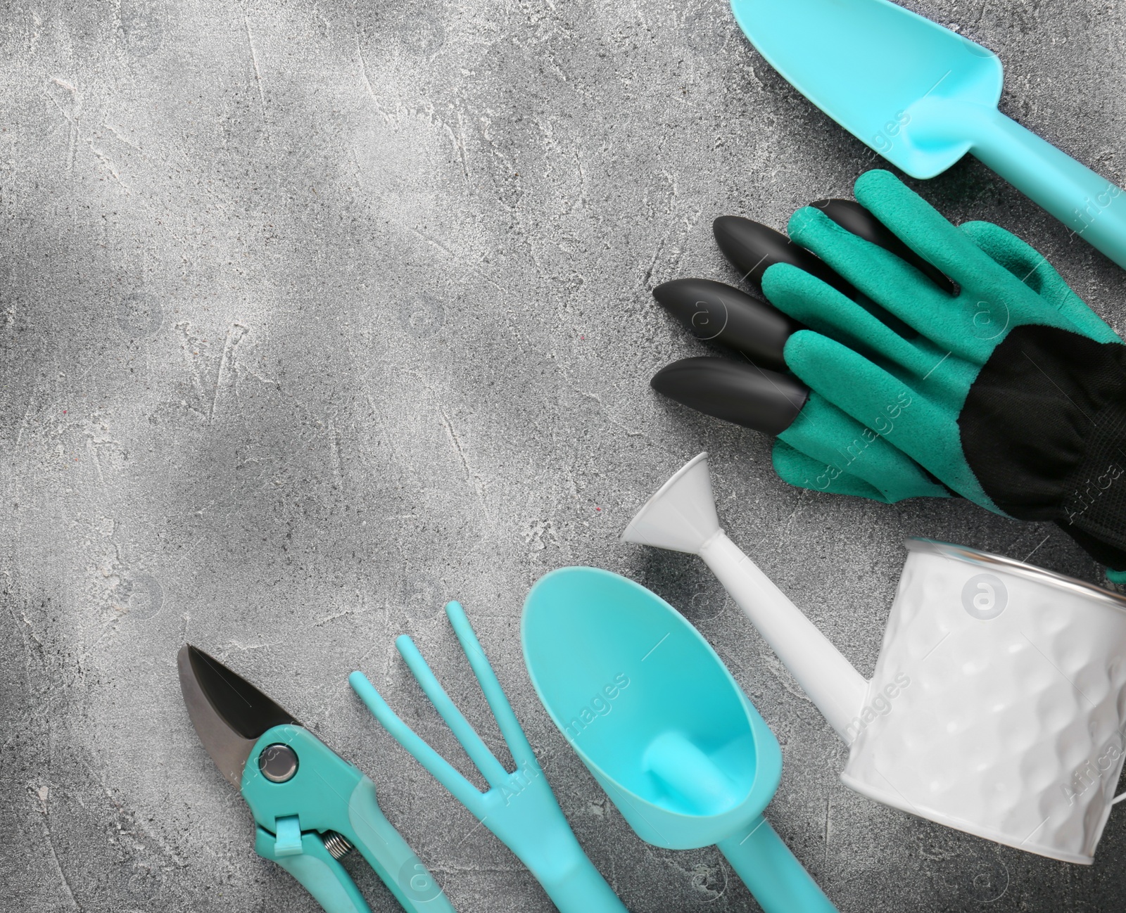 Photo of Flat lay composition with watering can and gardening tools on light grey background. Space for text