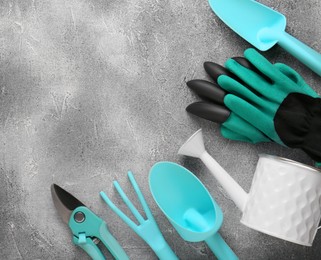 Photo of Flat lay composition with watering can and gardening tools on light grey background. Space for text