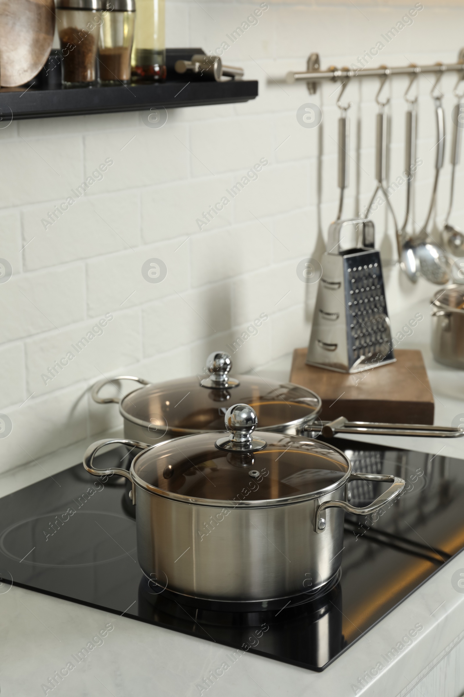 Photo of Pot and pan on electric stove in kitchen. Cooking utensils