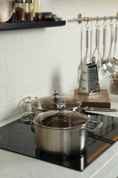 Pot and pan on electric stove in kitchen. Cooking utensils