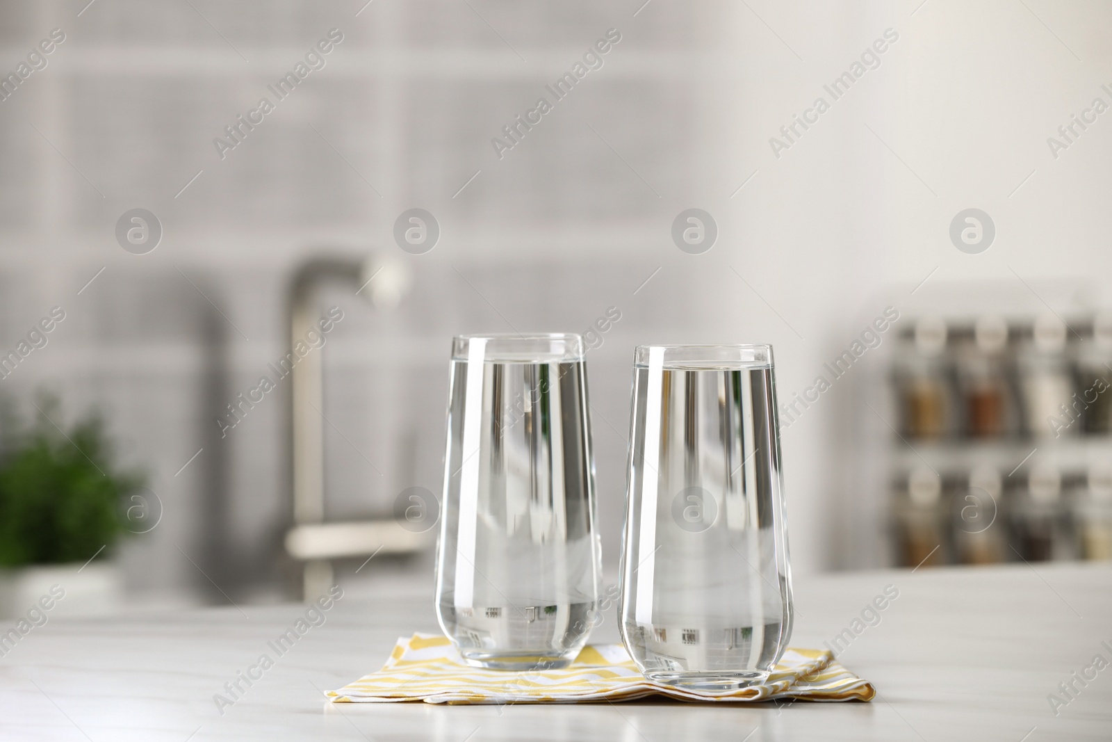 Photo of Glasses of pure water on white table indoors