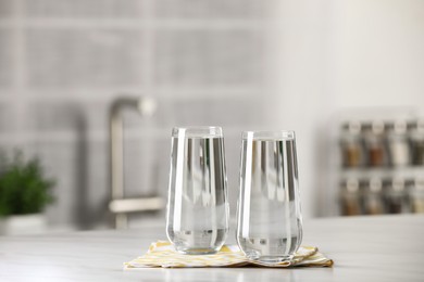 Glasses of pure water on white table indoors