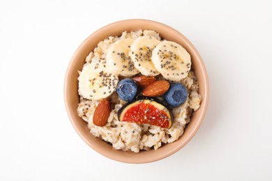 Bowl of oatmeal with blueberries, almonds, banana and fig pieces isolated on white, top view