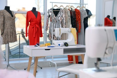 Dressmaking workshop interior with stylish female clothes and equipment