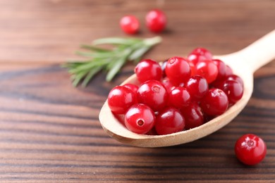 Photo of Fresh ripe cranberries on wooden table, closeup. Space for text