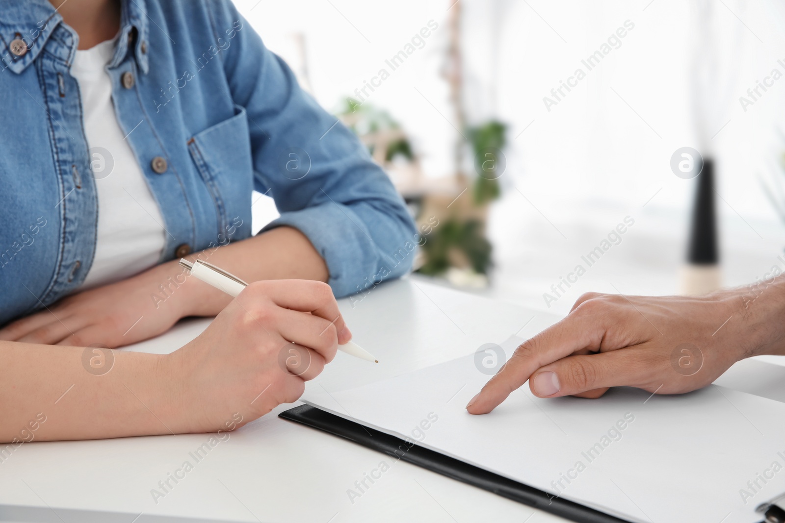 Photo of Young male receptionist working with client in hospital