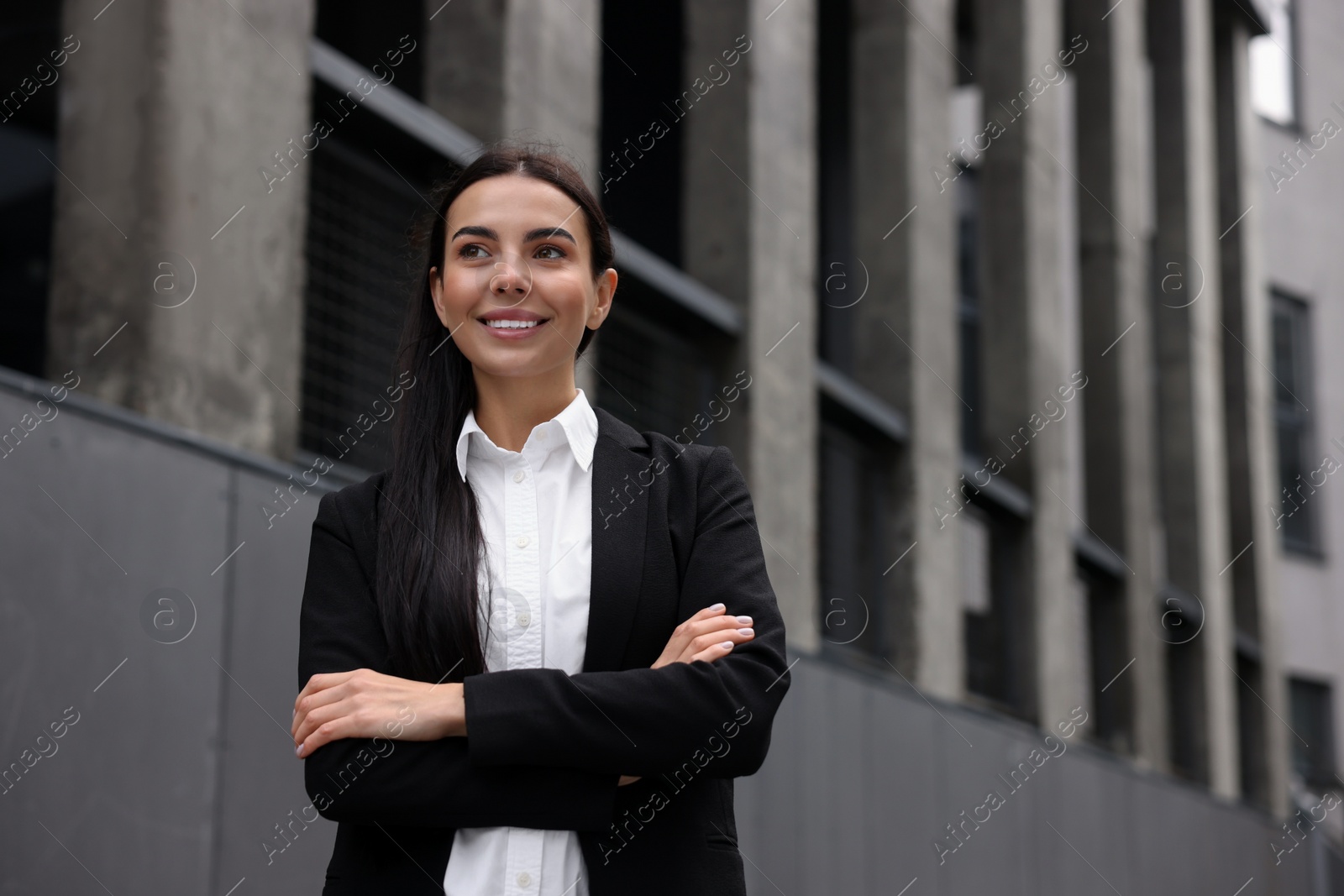 Photo of Portrait of smiling woman with crossed arms outdoors, space for text. Lawyer, businesswoman, accountant or manager