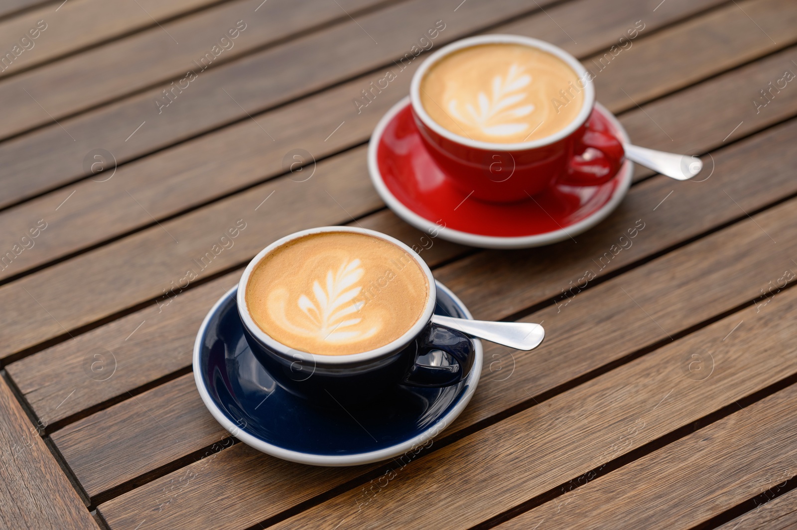 Photo of Cups of aromatic coffee on wooden table