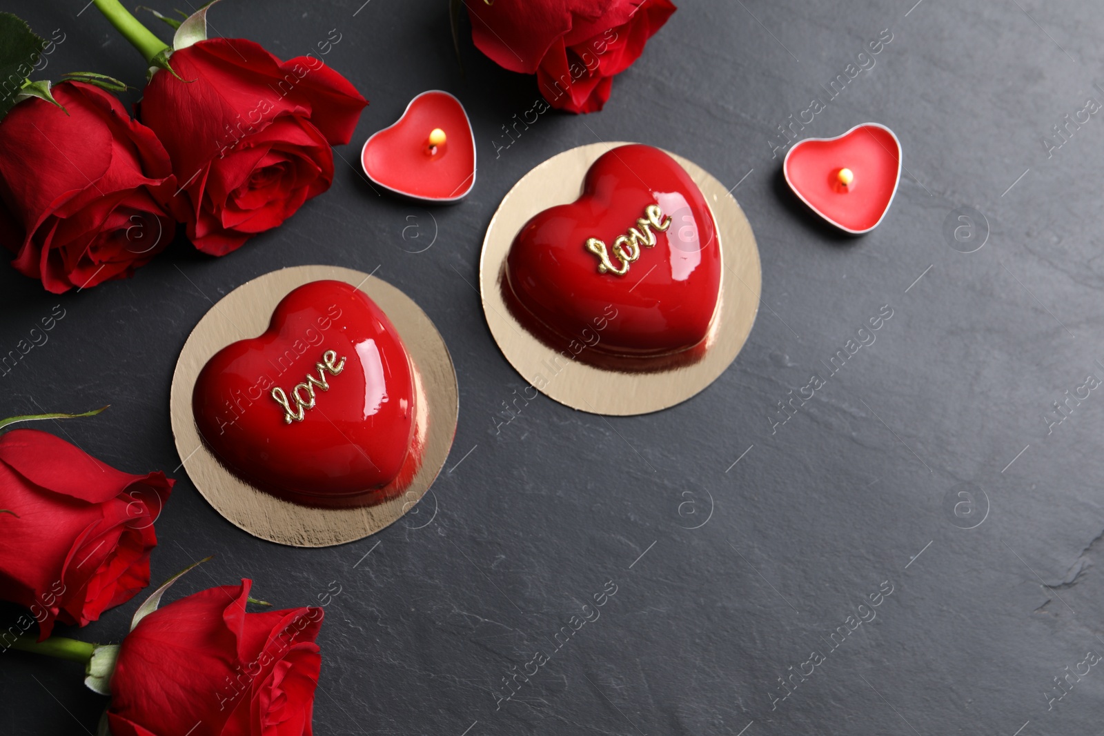 Photo of St. Valentine's Day. Delicious heart shaped cakes, roses and candles on black table, flat lay. Space for text