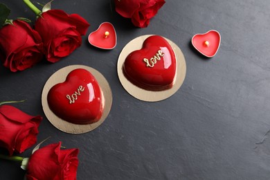 Photo of St. Valentine's Day. Delicious heart shaped cakes, roses and candles on black table, flat lay. Space for text