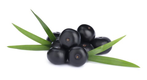 Photo of Pile of fresh ripe acai berries and green leaves on white background