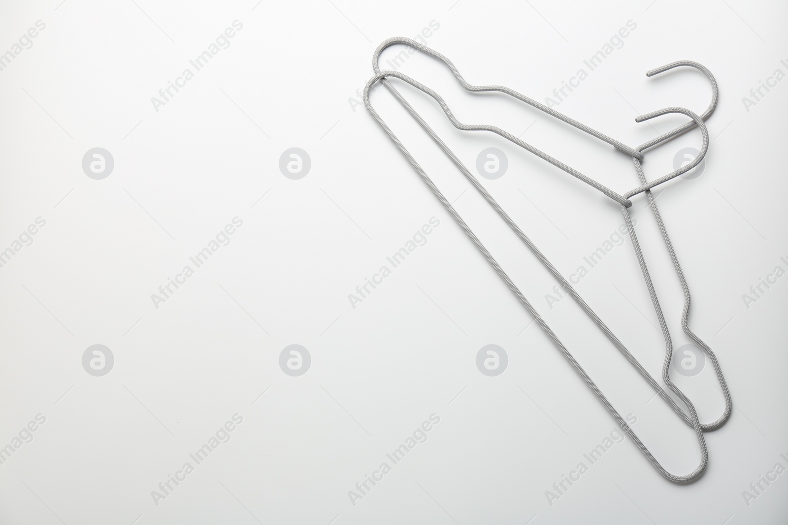 Photo of Hangers on white background, top view. Space for text
