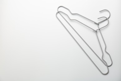 Photo of Hangers on white background, top view. Space for text