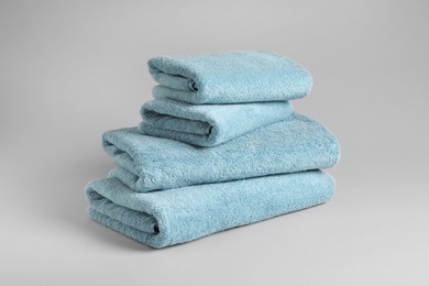 Stack of fresh fluffy towels on grey background