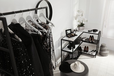 Shelving unit with stylish women's shoes, clothes and accessories in dressing room