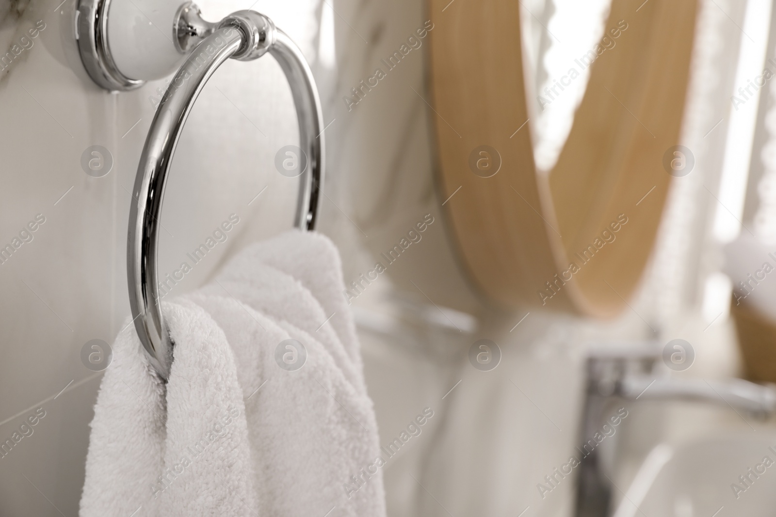 Photo of Holder with clean towel on light wall in bathroom, closeup