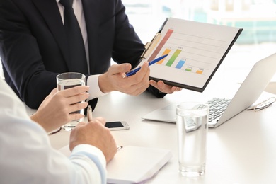 Photo of Male manager consulting mature couple in office