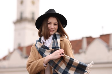 Photo of Beautiful woman in warm scarf and hat outdoors