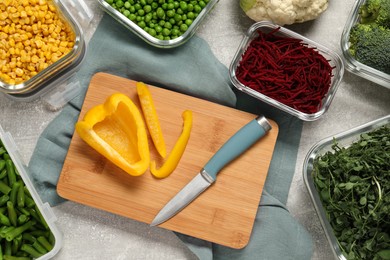 Photo of Cut bell pepper, knife and containers with fresh products on light gray table, flat lay. Food storage