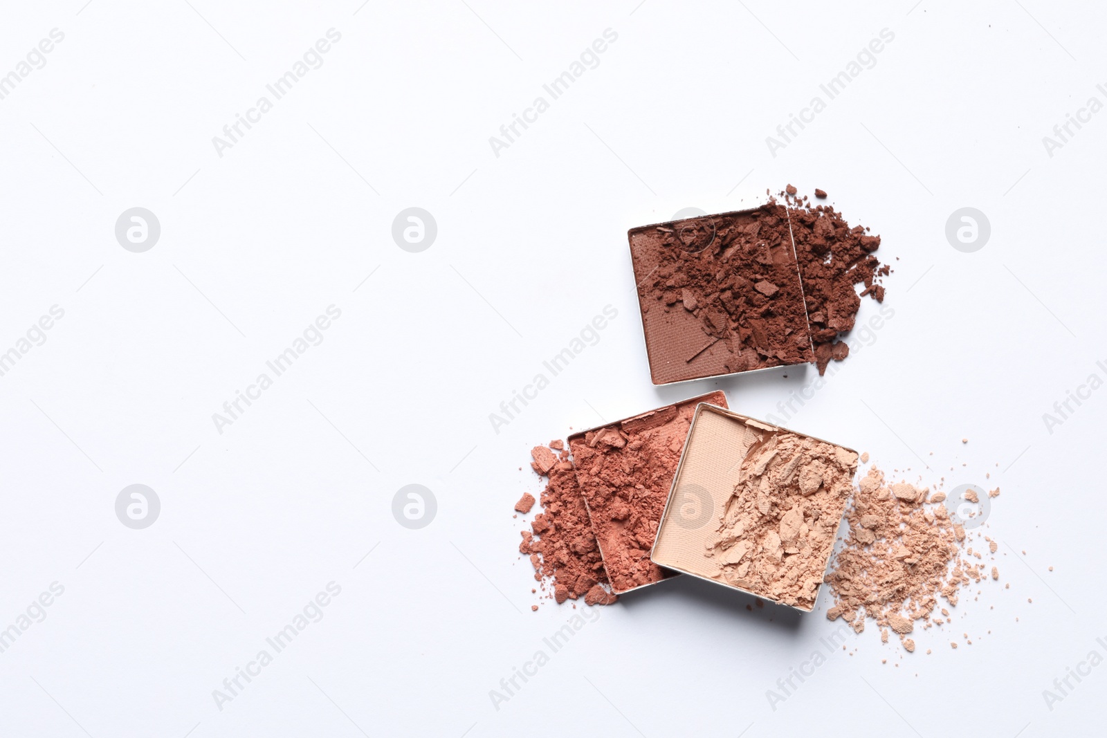 Photo of Different crushed eye shadows on white background, top view