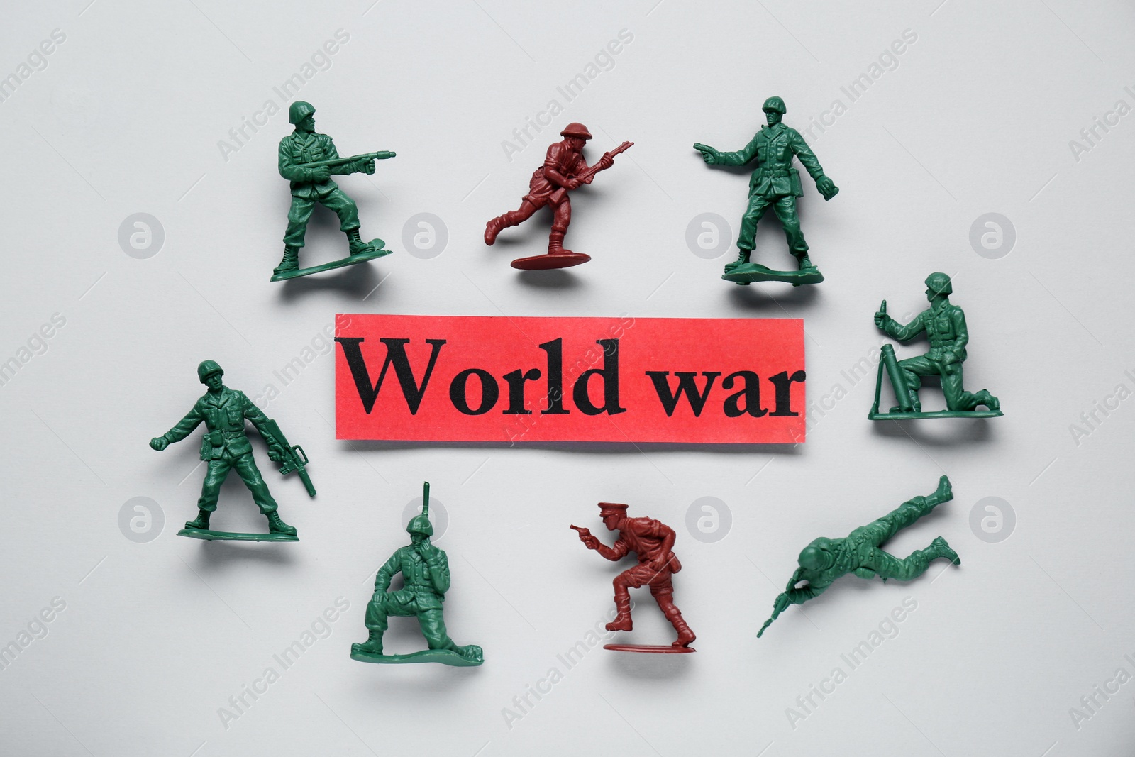 Photo of Paper with words World War and toy soldiers on white background, flat lay