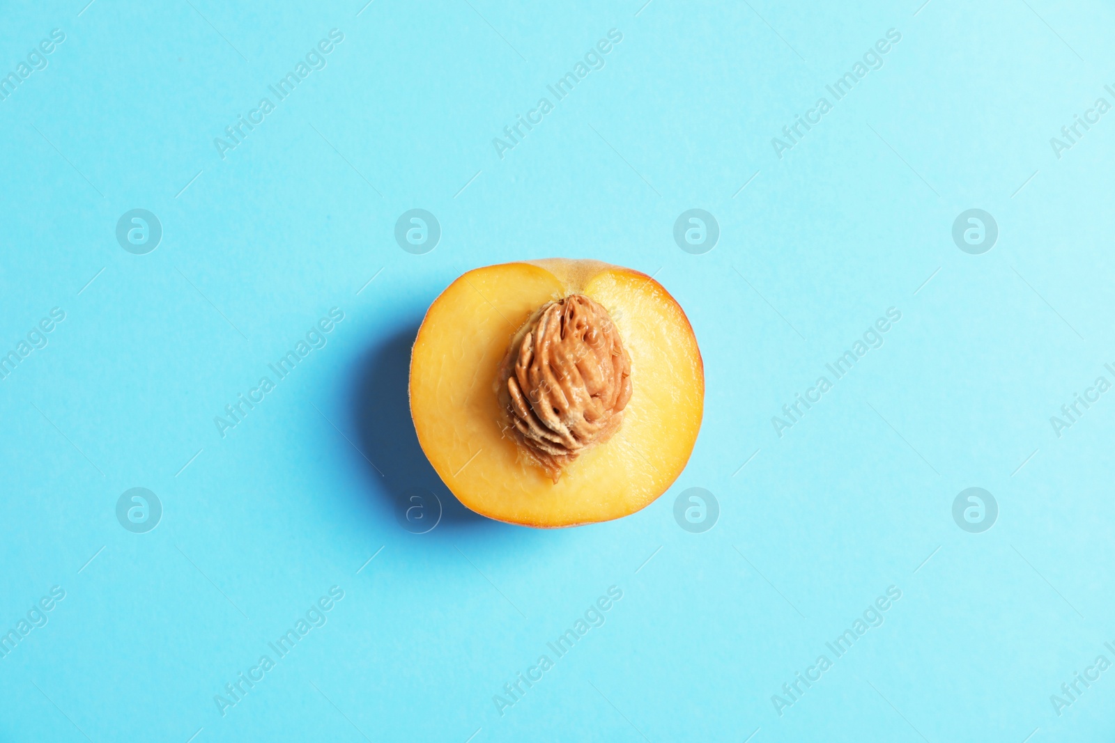 Photo of Half of fresh sweet peach on color background, top view