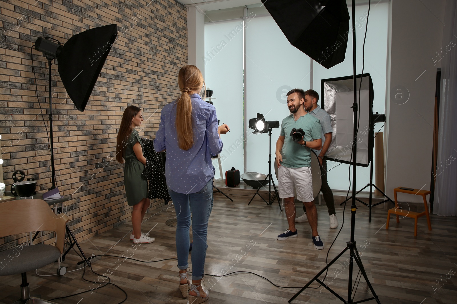 Photo of Professional team working with model in photo studio