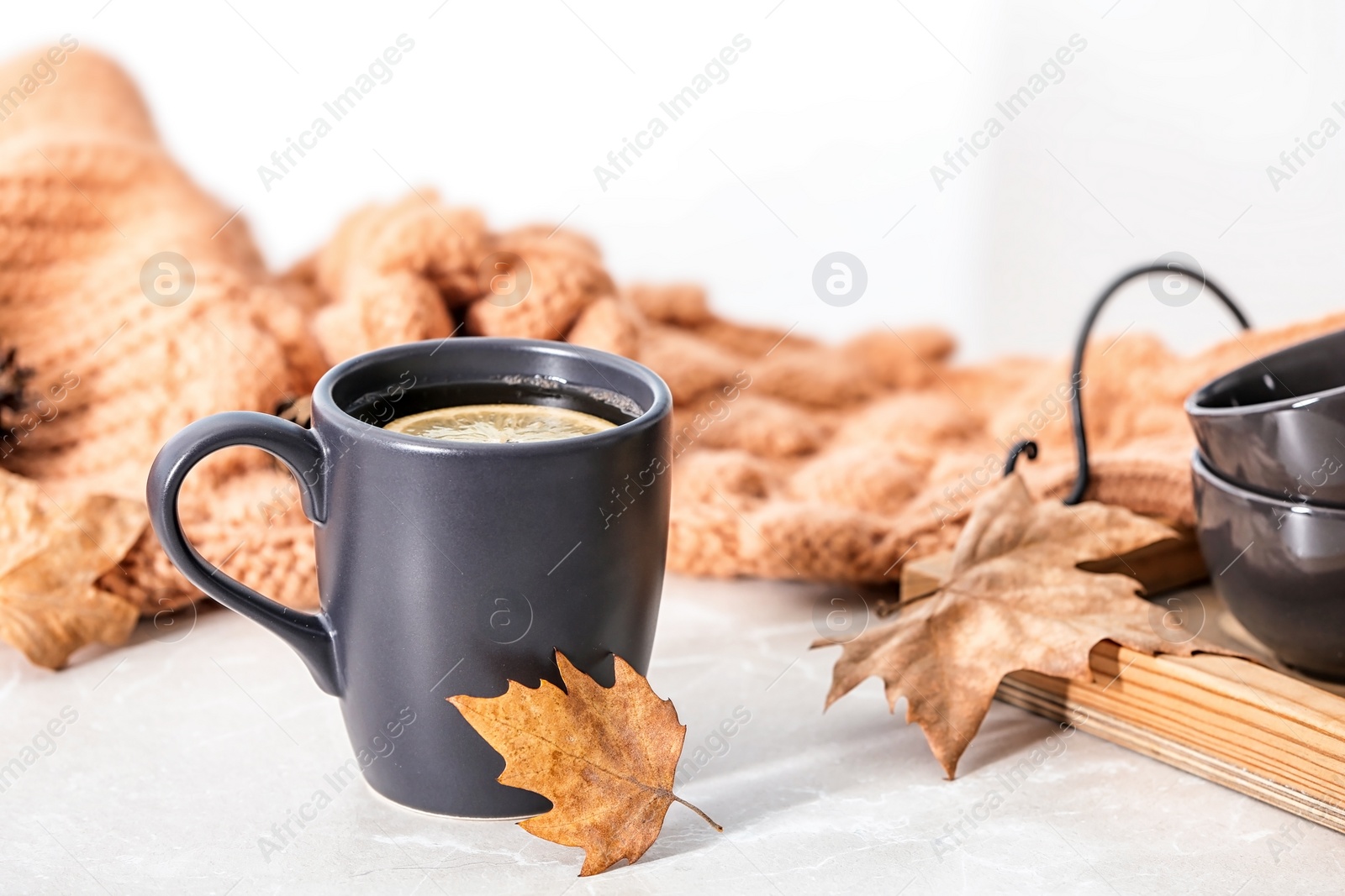 Photo of Composition with hot cozy drink and autumn leaves on table