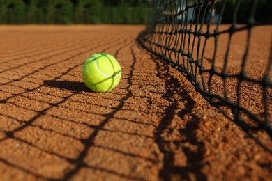 Photo of Tennis ball near net on clay court