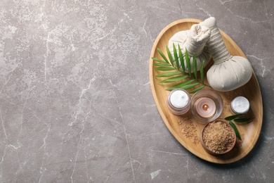 Photo of Tray of spa items on grey table, top view. Space for text