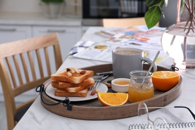 Tray with tasty breakfast on white table