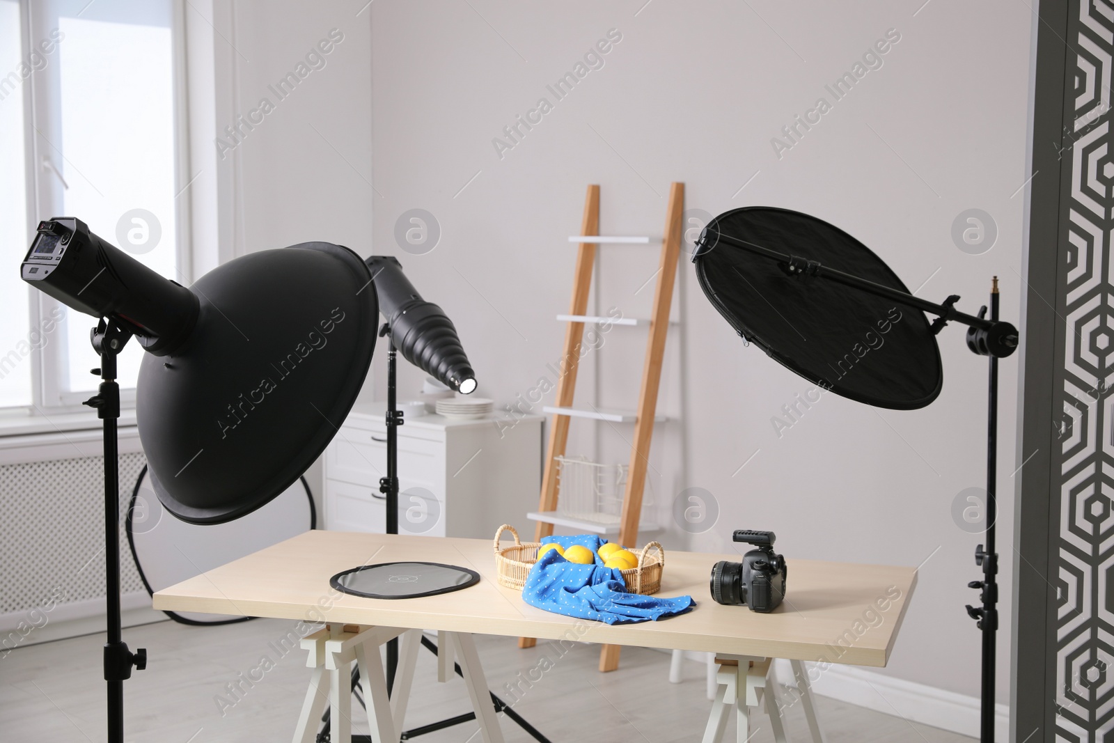 Photo of Professional camera and composition with ripe lemons on table in photo studio. Food photography