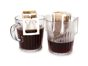 Photo of Glass cups with drip coffee bags isolated on white