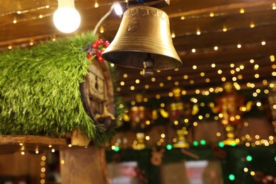 Photo of Decorative bell on blurred background. Christmas fair stall, closeup view