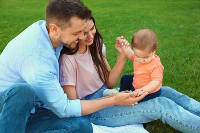 Photo of Happy family with adorable little baby outdoors