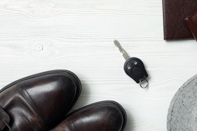 Flat lay composition with male accessories and car key on white wooden background