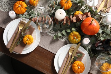 Beautiful autumn table setting. Plates, cutlery, glasses, pumpkins and floral decor, flat lay