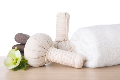 Photo of Flower and spa supplies on wooden table against white background