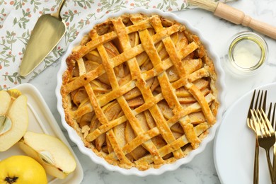Photo of Tasty homemade quince pie served on white marble table, flat lay