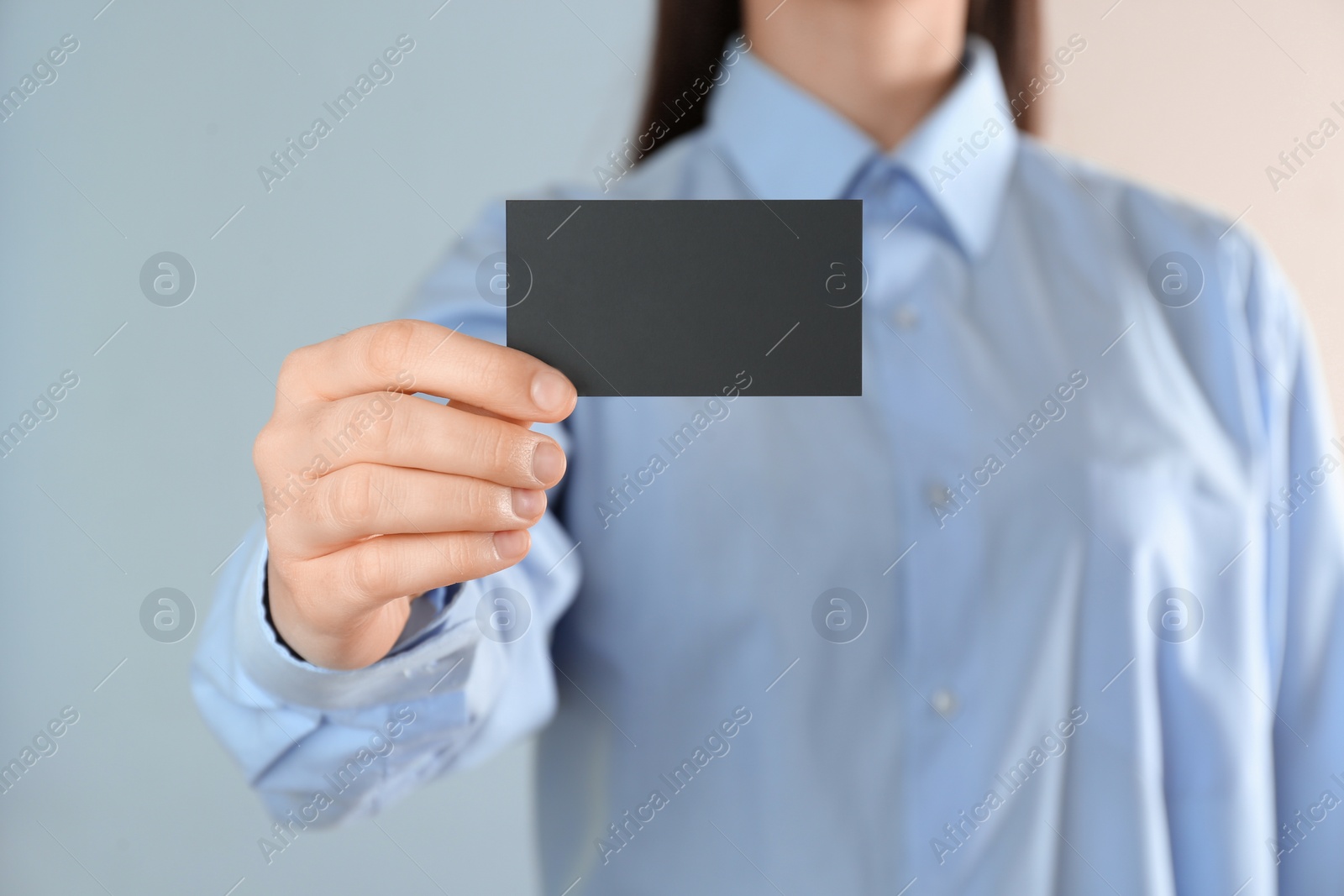 Photo of Woman holding blank business card on color background, closeup. Mockup for design