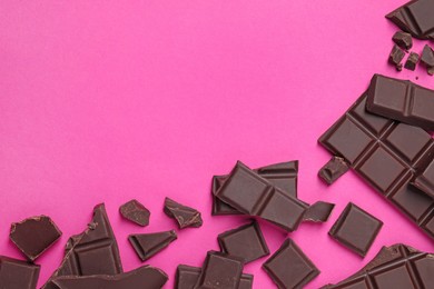 Photo of Pieces of delicious chocolate bars on pink background, flat lay. Space for text